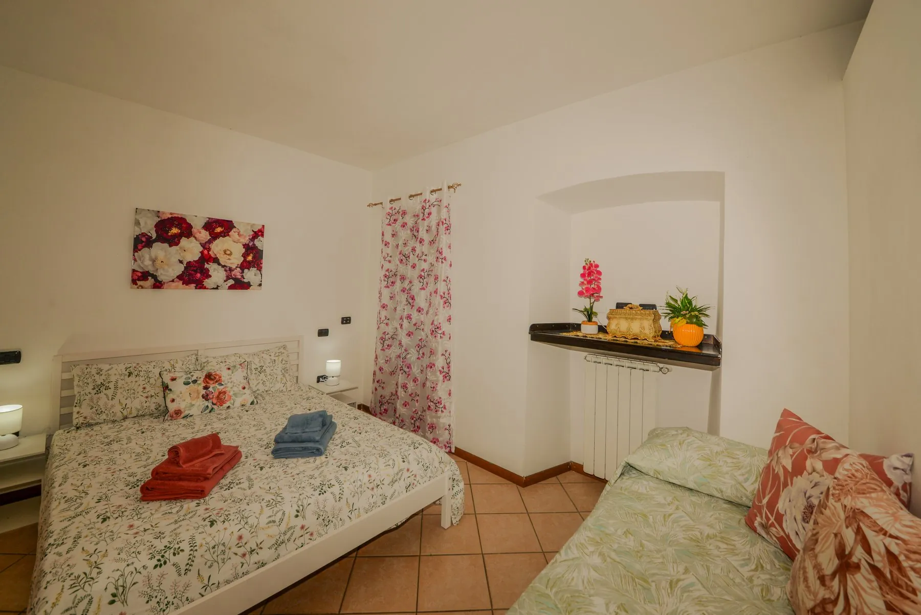 La camera matrimoniale, con il letto singolo e la porta finestra
